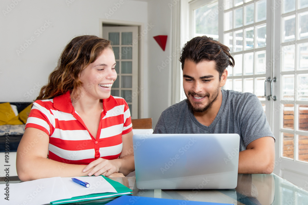 Caucasian woman with latin american boyfriend at computer Caucasian woman with latin american boyfriend at computer