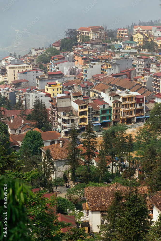 Cityscape on the mountain with fog, trees and mountain thar view from above in summer in Sa Pa, Vietnam.