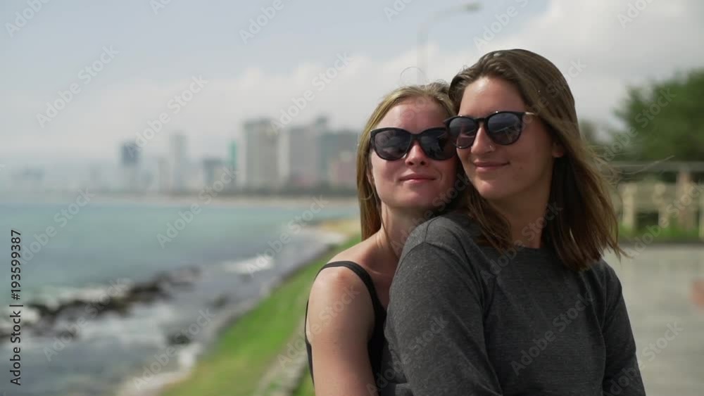 Happy lesbian couple hugs with beautiful sea view dawn rapid slow motion Happy lesbian couple hugs with beautiful sea view dawn rapid slow motion
