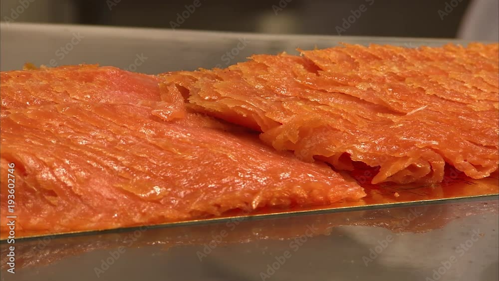 A close up detailed shot of a fish meat in a supermarket. The fish is prepared and orange in color.