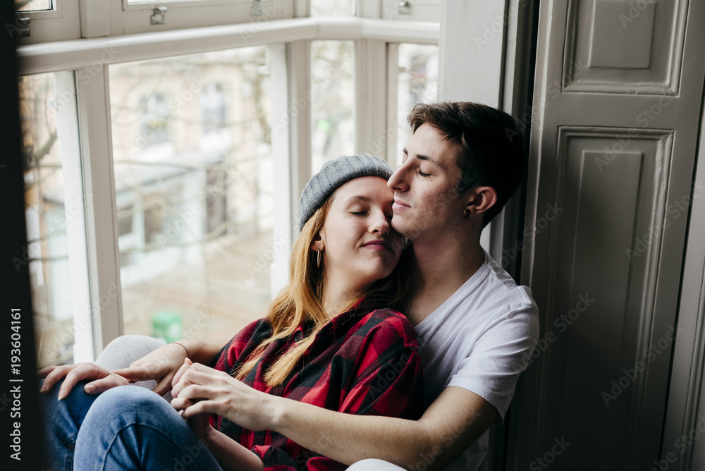 Couple hugging on window sill Couple hugging on window sill