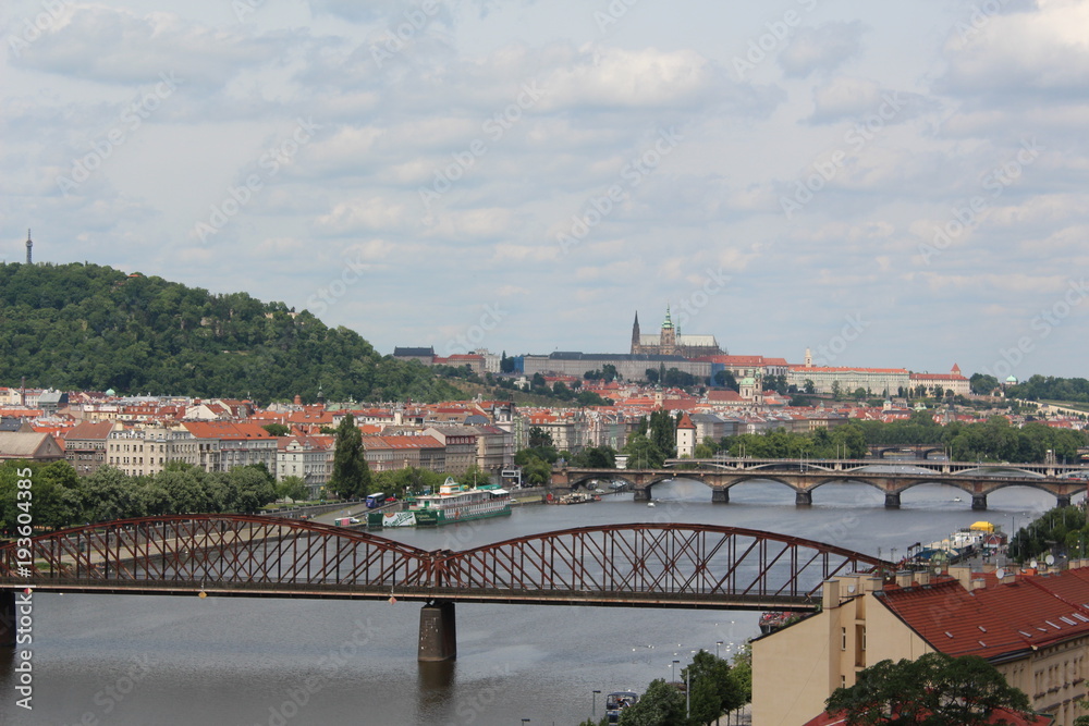 Bridges over Vltava river, Prague, Czech Republic. St. Vitus Cathedral םn the horizon, cloudy sky above.