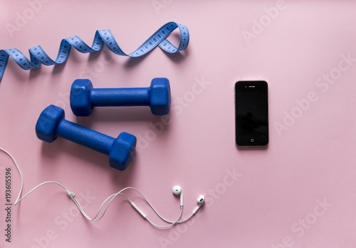 on a pink background boxing glove blue color ribbon centimeter phone smartphone with headphones white 