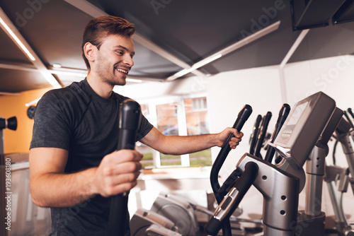 A man in the gym. He leads a healthy lifestyle. A man is engaged in an elliptical trainer.