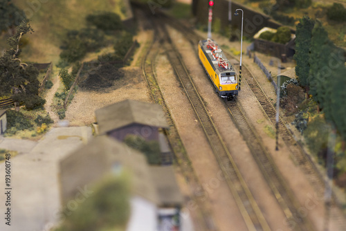 Set of red electric model railway locomotive and layout with a station and whole scene with features.