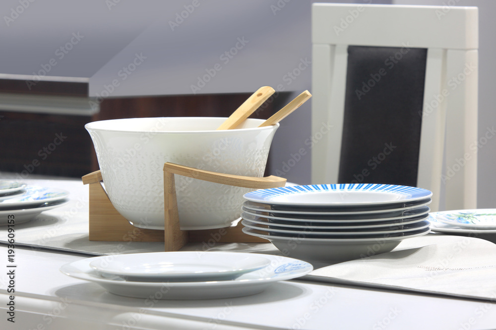 Porcelanowy zestaw czystych talerzy na stole w kuchni. - obrazy, fototapety, plakaty 