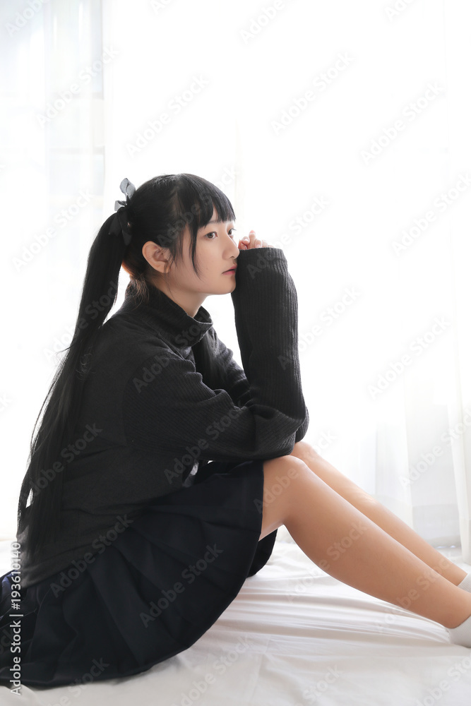 Young pretty girl wearing black cotton sweatshirt on bedroom white tone Young pretty girl wearing black cotton sweatshirt on bedroom white tone