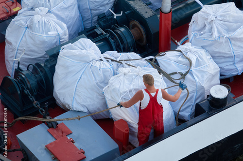 Worker in a red suit on a cargo ship photo