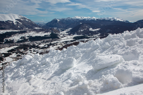 Manto di neve in primo piano e montagne sullo sfondo