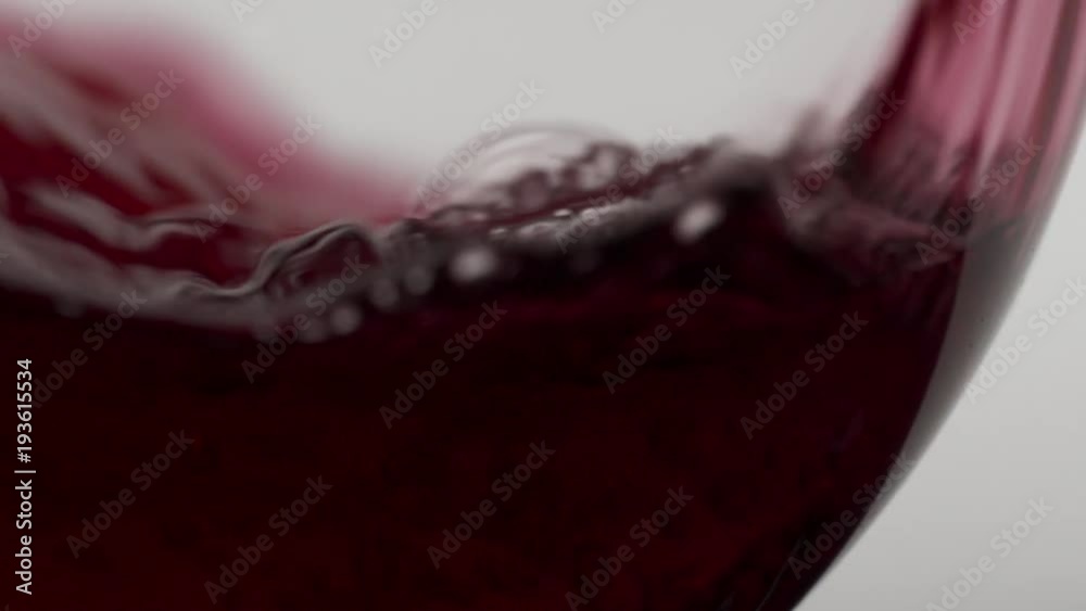 Red Malbec wind being poured into a glass in slow motion, stark white background. Passion style footage of Easter scenes