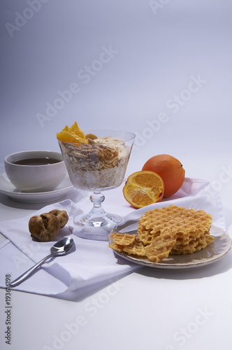 healthy breakfast on white. Oatmeal with yoghurt, figs, banana and orange and waffles