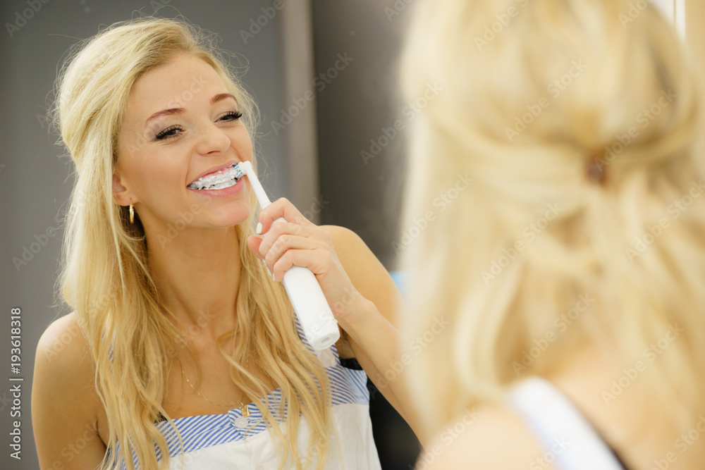 Woman using electric toothbrush Woman using electric toothbrush