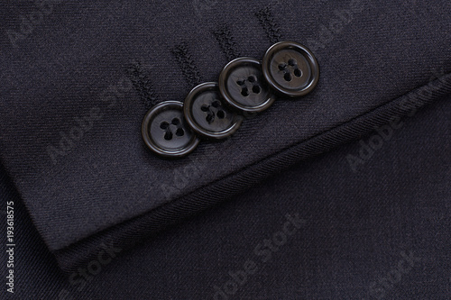 Buttons on the sleeve of a man's jacket. Textile. Background.