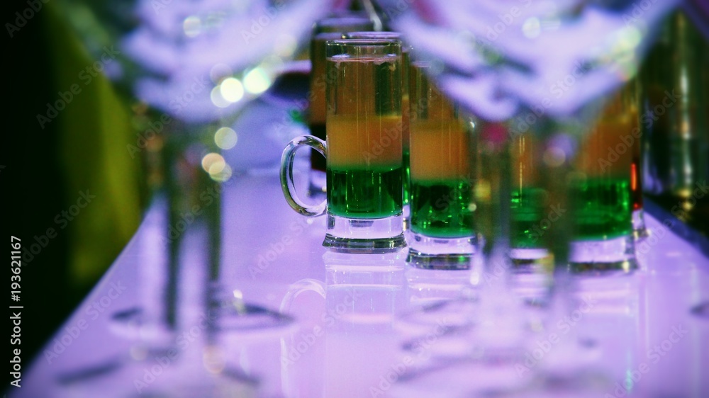 Illuminated bar desk with cocktails in variety glasses 

