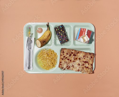 Overhead view of school lunch tray isolated on peach background