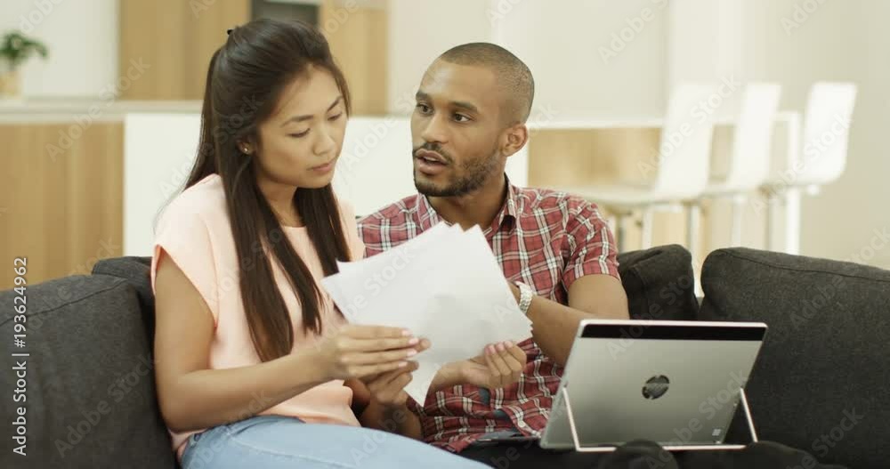 4k, married couple having a serious discussion about their home finances while inspecting a bill.
