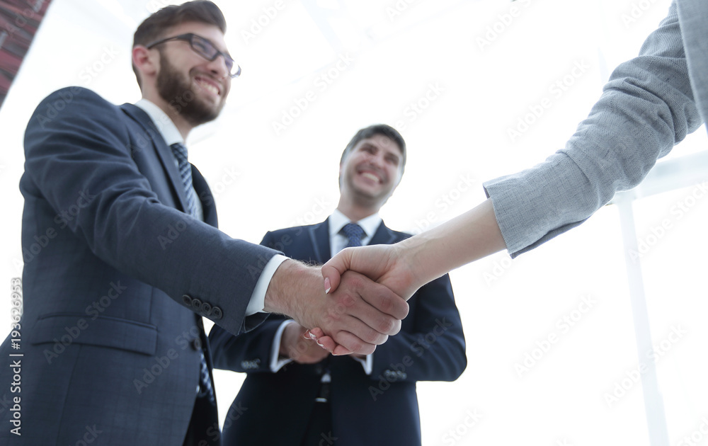 Business partners shaking hands in meeting hall Business partners shaking hands in meeting hall
