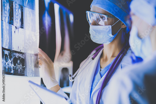 Two female women medical doctors looking at x-rays in a hospital. photo