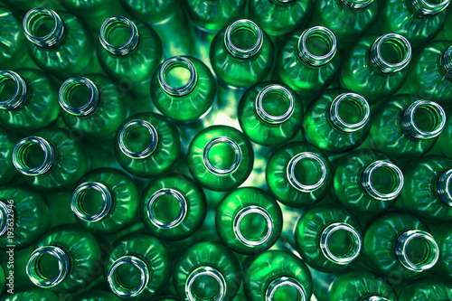 Bottling plant - Green glass bottles from above. Abstract background.