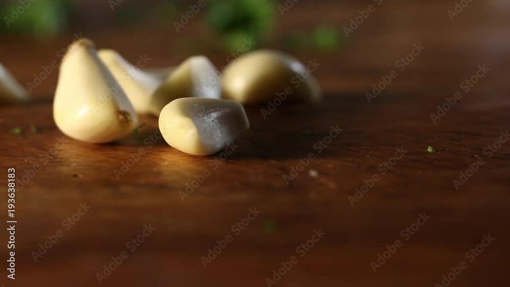 Bunch of peeled garlic cloves fall on table, close up Bunch of peeled garlic cloves fall on table, close up