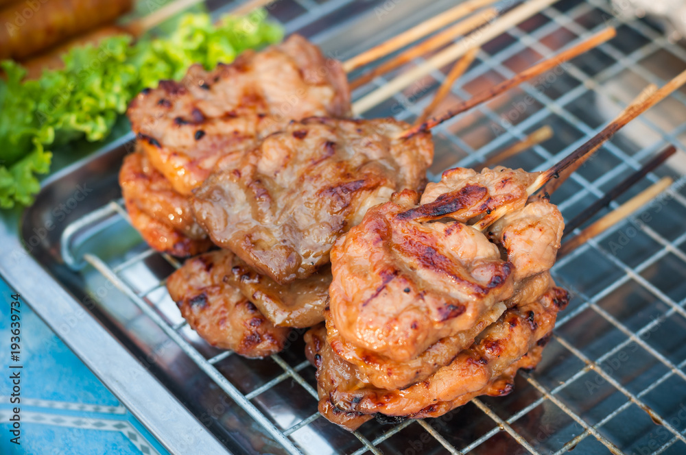 Close up Grilled Pork stick on grid  market, Thai cuisine traditional signature street food, quick delicious and easy eating