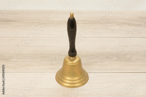Old antique bell on teacher's desk in school