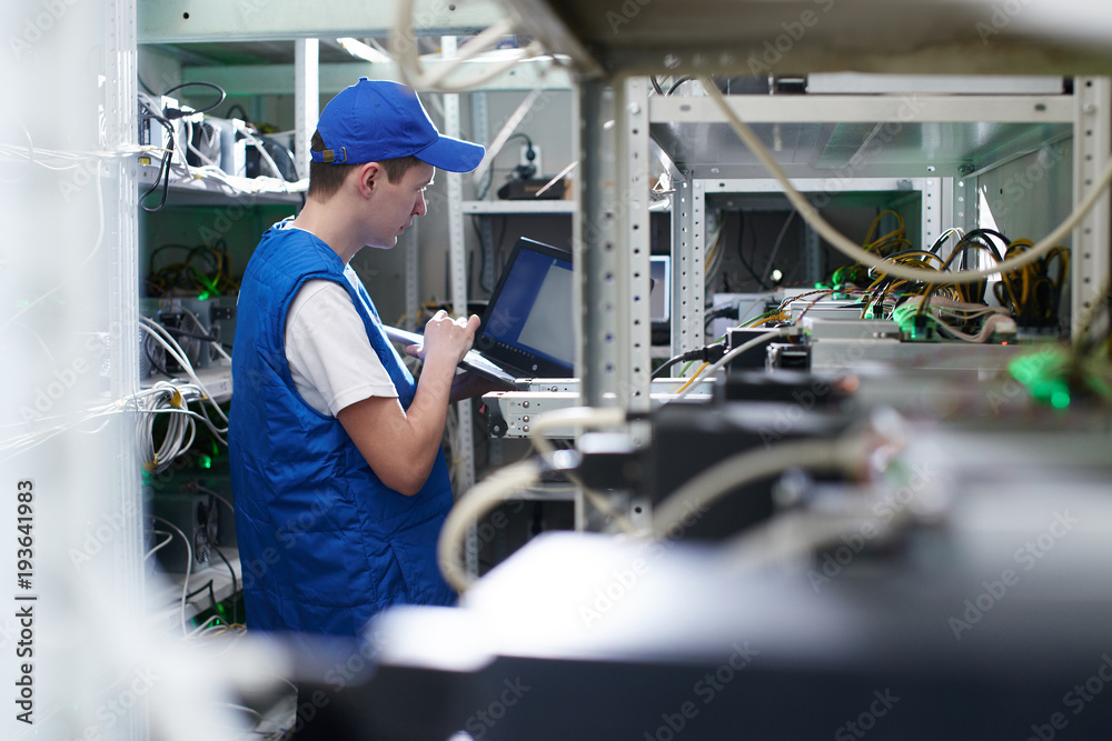 Mining. A man working on a farm for the extraction of crypto currencies. Bitcoin business