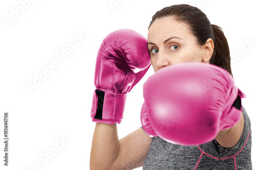 Fitness, Cancer awareness and boxing workout concept with attractive mature brunette woman wearing fitness clothes and pink boxing gloves, isolated on white with copy space and a clipping path