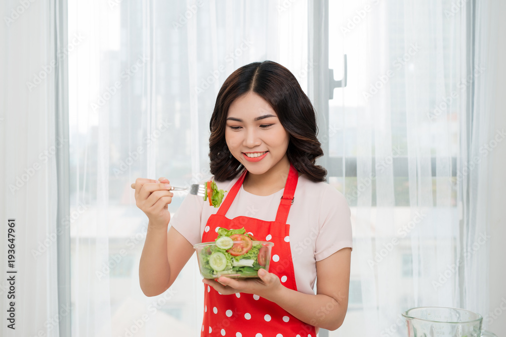 Happy asian woman eating salad from glass bowl. Halthy food. Happy asian woman eating salad from glass bowl. Halthy food.