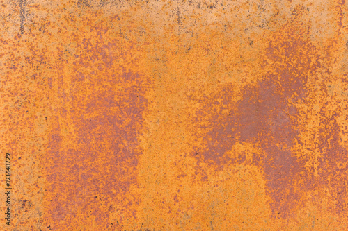 Textured background of a faded yellow paint with rusted cracks on rusted metal. Grunge texture of an old cracked metal surface. Rusty yellow-red stains