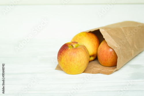 fresh ripe apples in a paper package on a white backgroung