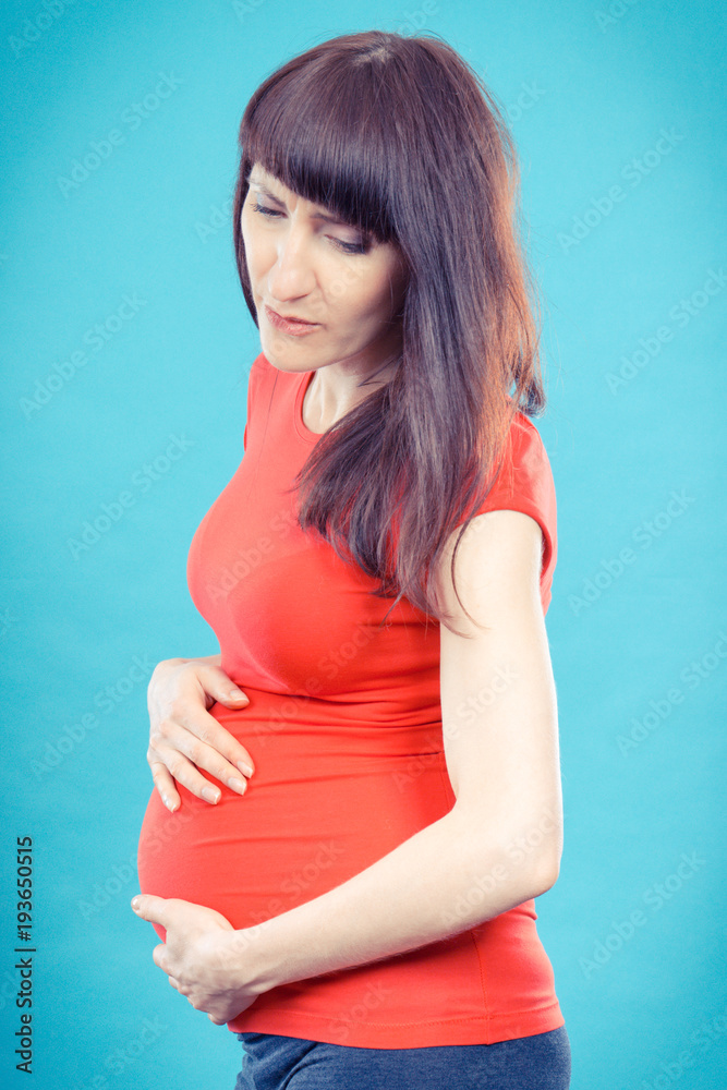 Sad woman in pregnant with stomach pain touching her belly, aches in