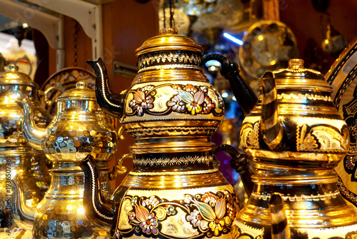 Traditional Turkish handicrafts. Copper souvenir teapots with a bright oriental ornament on the market