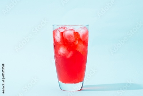 Soda. Red sparkling water with ice in a glass