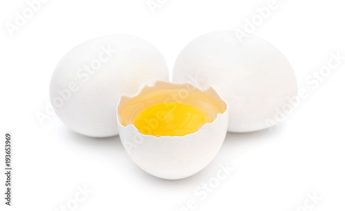 One broken egg with two whole eggs on white background.