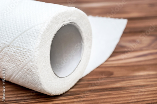 Roll of paper towel on the wooden table. Close up.