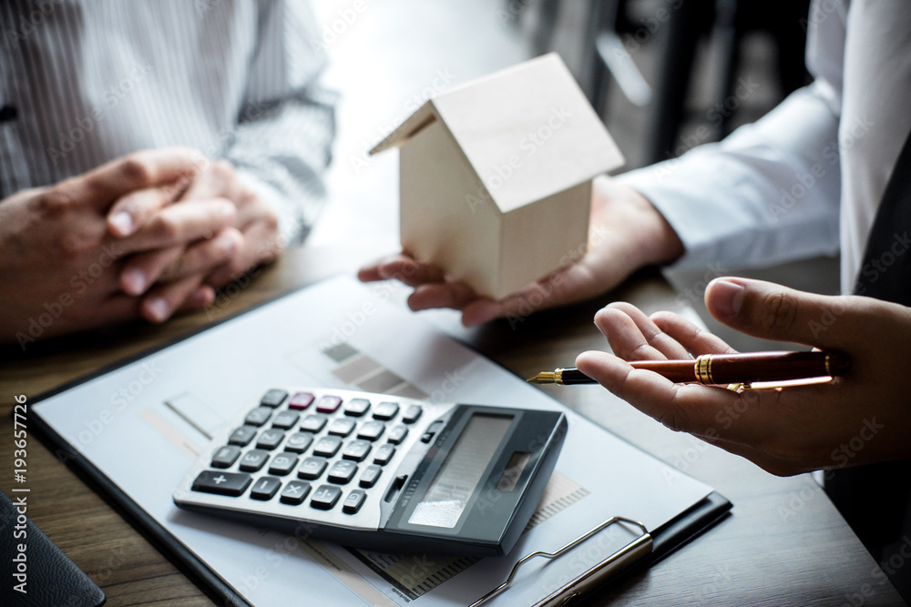 Real estate broker agent being analysis and making the decision a home estate loan to customer, Agent man is using calculator to presentation detail and waiting for his reply to finish Real estate broker agent being analysis and making the decision a home estate loan to customer, Agent man is using calculator to presentation detail and waiting for his reply to finish