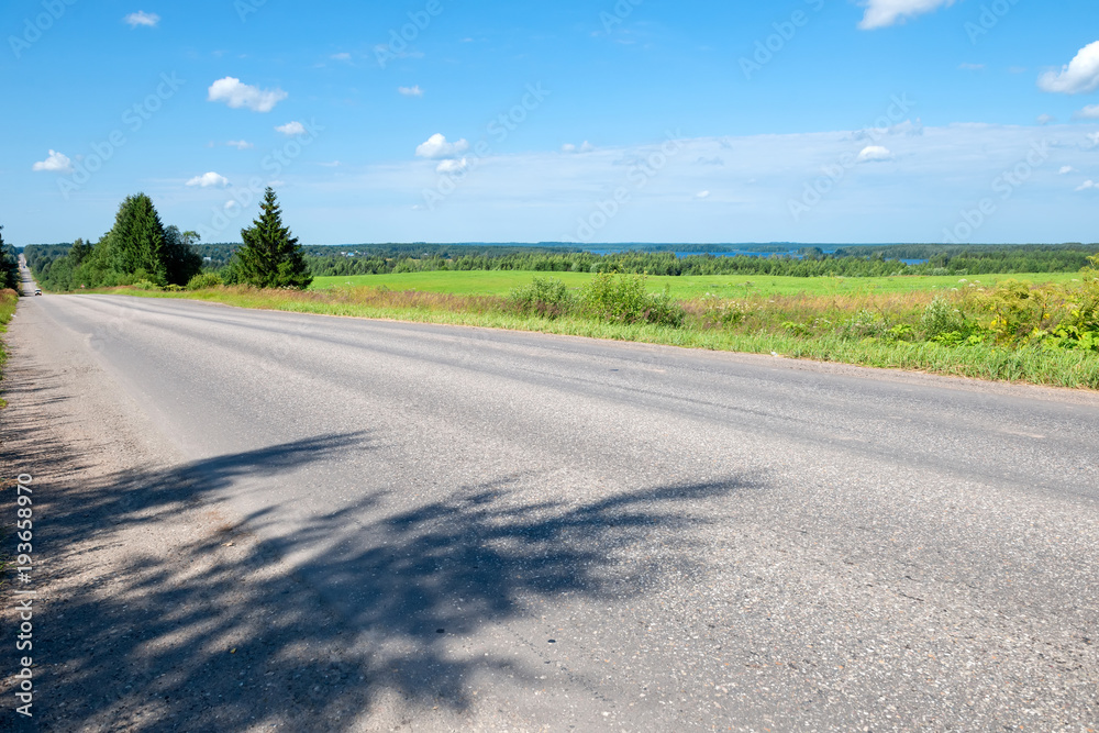 Romantic road into the distance, horizon, lake and green flat plain Romantic road into the distance, horizon, lake and green flat plain