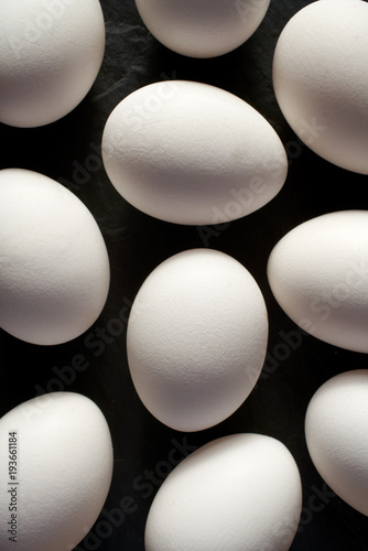 Chicken eggs with white shells on a black background, top view, close-up 