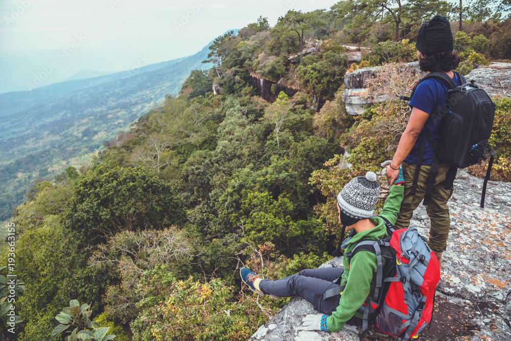 Obraz premium Asian lover women and men travel nature. Travel relax. watch mountain view. On a cliff on the mountain. Thailand