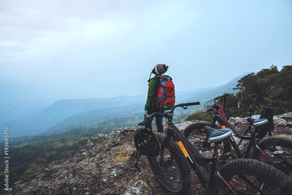  Asian women Travel photograph Nature. Travel relax ride a bike Wilderness in the wild. Standing on a rocky cliff. Thailand