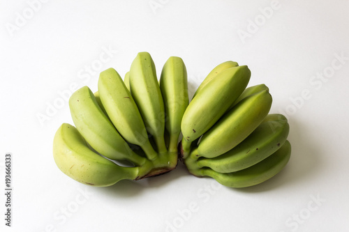 Bunches of green, underripe baby bananas fanned out, copy space, isolated on white © Natalie Schorr