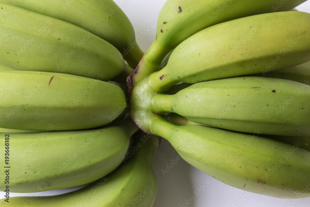 Closeup of green and yellow baby bananas, horizontal aspect