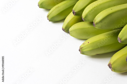 Diagonal composition of green and yellow baby bananas, good copy space, horizontal aspect © Natalie Schorr