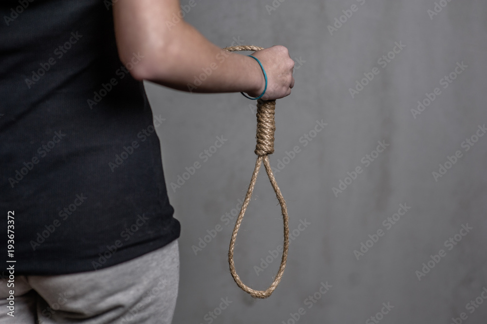 Female hand holding rope loop, suicide concept. Space for text