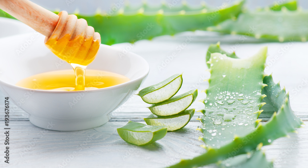 Aloe Vera with honey closeup on white wooden background. Sliced Aloevera  natural organic renewal cosmetics, alternative medicine. Aloe vera gel,  organic skincare concept Stock Photo | Adobe Stock