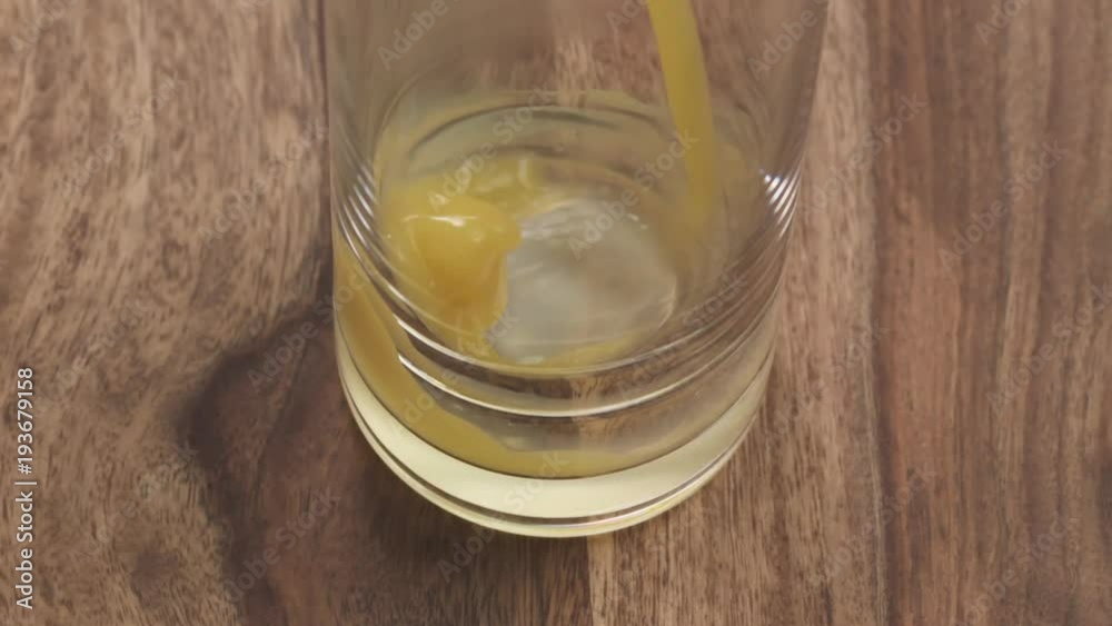 Slow motion handheld closeup orange juice pour into glass Slow motion handheld closeup orange juice pour into glass