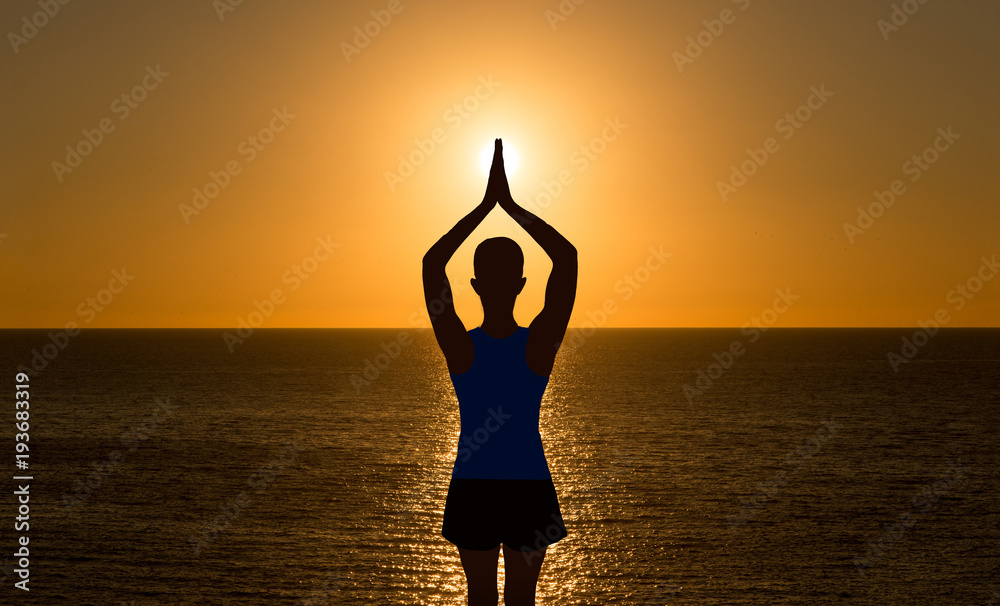 A girl practicing yoga in a sunset