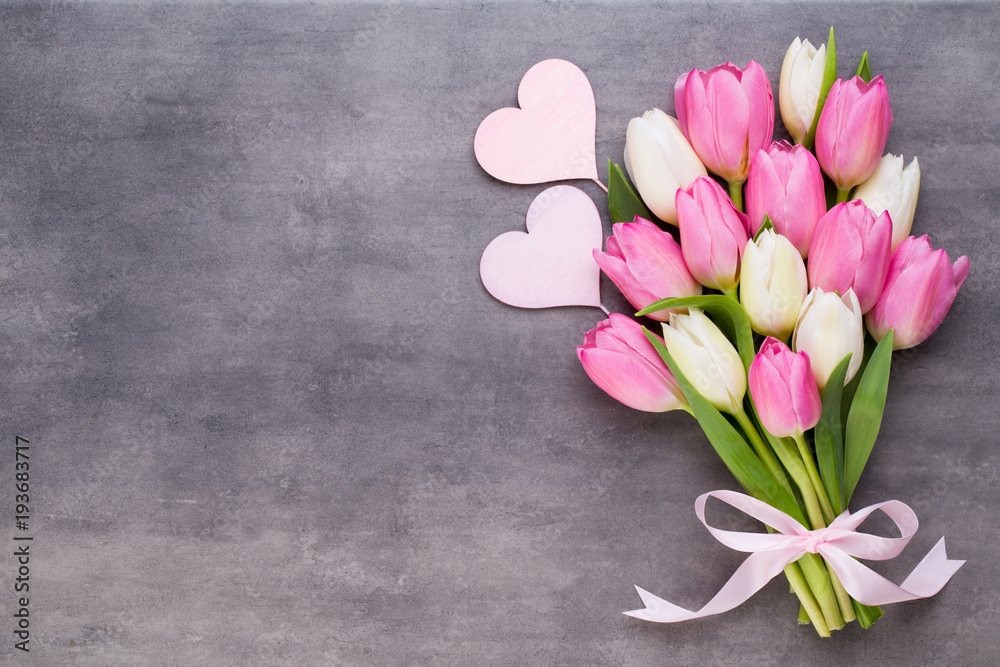 Naklejka premium Dzień Matki, dzień kobiety, Wielkanoc, różowe tulipany, prezenty na szarym tle.