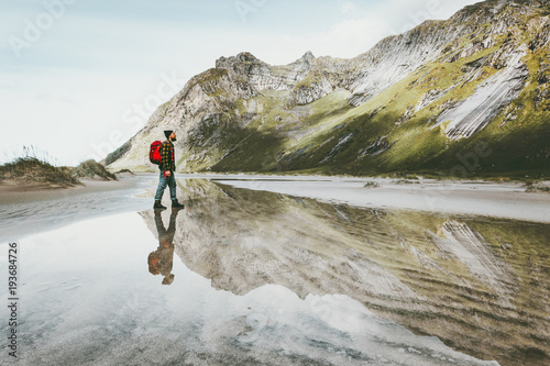 Man walking alone at sandy beach in mountains Travel lifestyle emotional concept adventure outdoor summer vacations wild nature water reflection